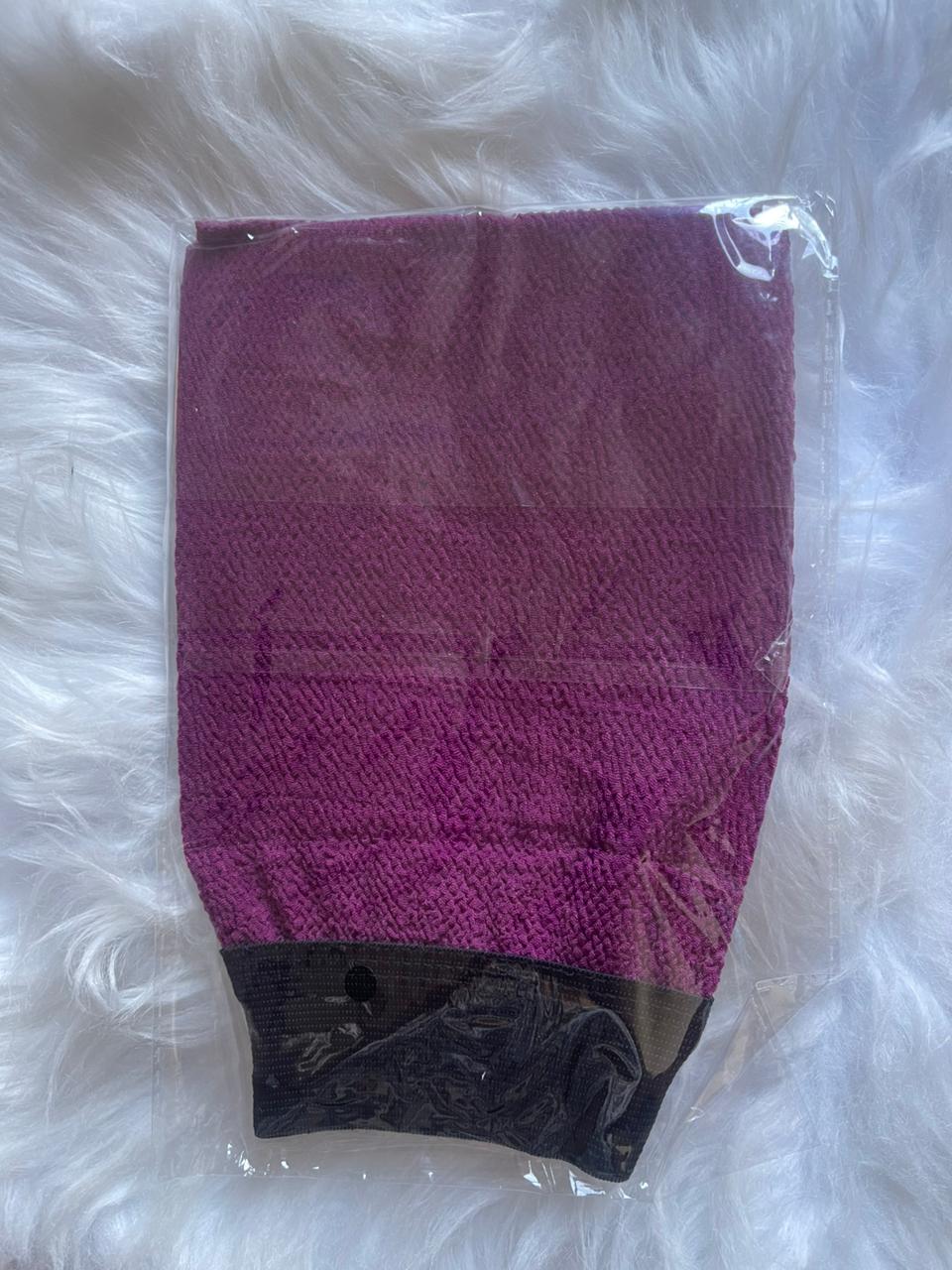 Purple and black textured product in clear packaging on a white fluffy surface