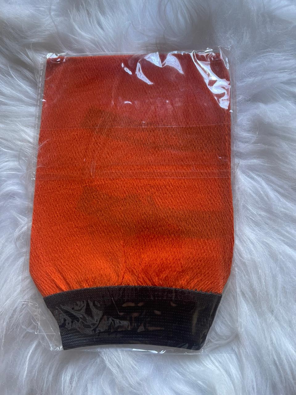 Orange and black textured product in clear packaging on a white fluffy surface